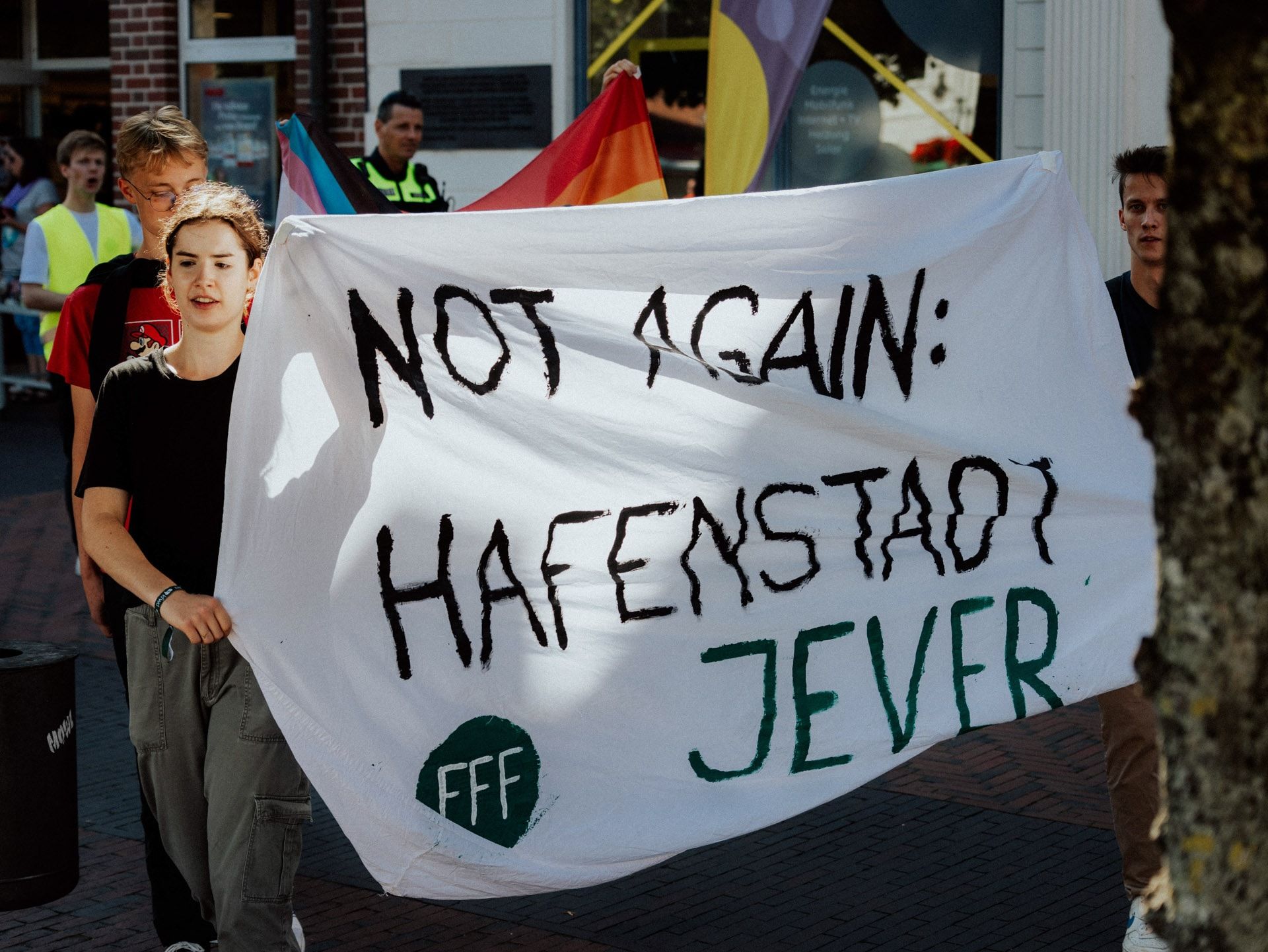 Aktivist*innen von FFF halten ein Banner in Jever, auf dem steht: "Not again: Hafenstadt Jever"